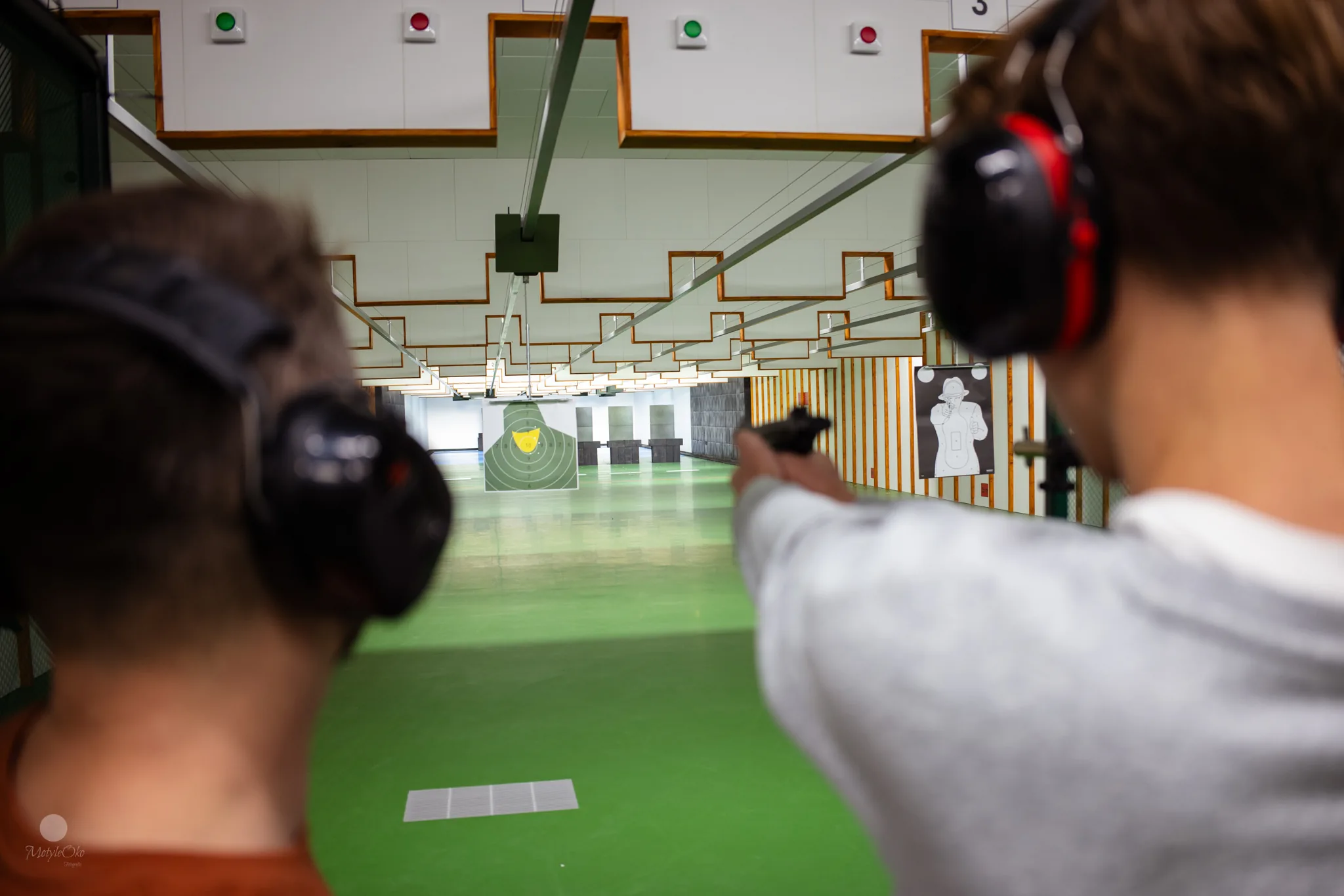 Integracja firmowa na strzelnicy, uczestnicy w ochronnikach słuchu
